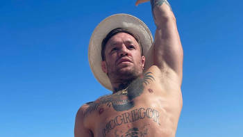 Conor McGregor does stretches in his budgie smugglers as UFC icon hits beach with pregnant fiancee Dee Devlin and kids