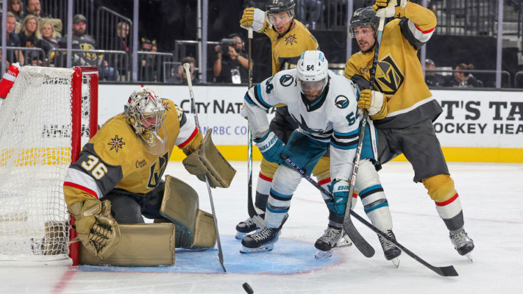 Logan Thompson of the Vegas Golden Knights makes a save as Givani Smith of the San Jose Sharks and Ben Hutton and Brayden Pachal of the Golden Knights look for a rebound. Photo by Getty Images.