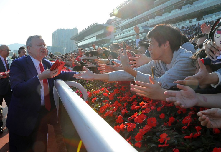 Jockey Club chief executive Winfried Engelbrecht-Bresges hands out lai see packets at Sha Tin on Monday. Photo: Kenneth Chan