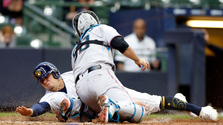 Luis Urias of the Milwaukee Brewers is tagged out at home plate by catcher Jacob Stallings of the Miami Marlins. Photo by Getty Images.