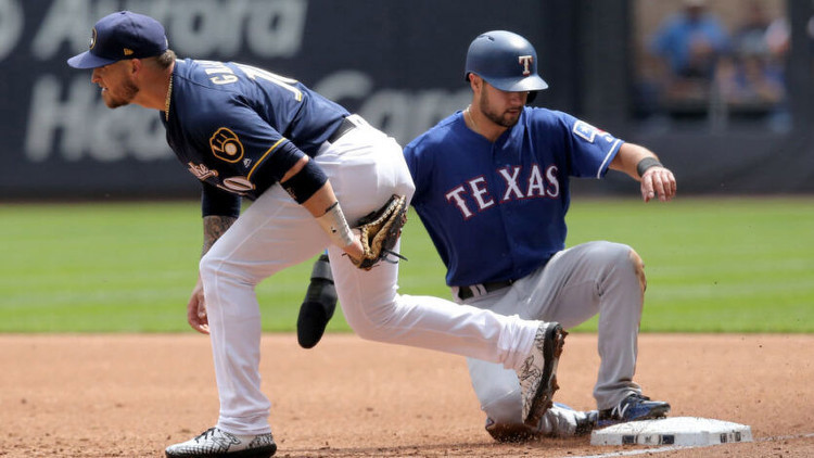 Yasmani Grandal of the Milwaukee Brewers doubles up Isiah Kiner-Falefa of the Texas Rangers. Photo by Getty Images.