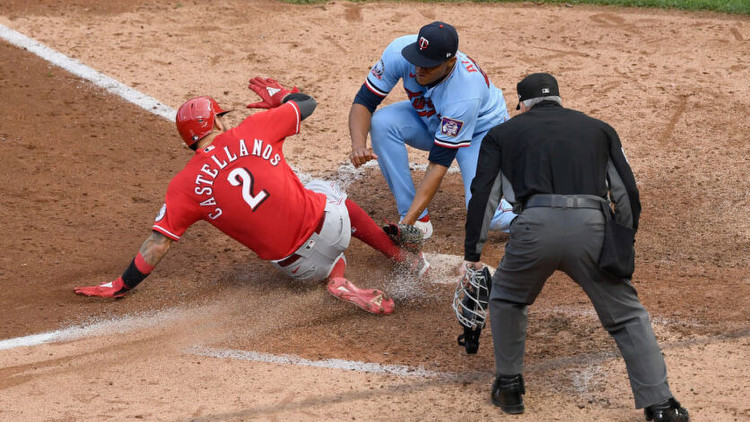 Jorge Alcala of the Minnesota Twins defends home plate from Nick Castellanos of the Cincinnati Reds. Photo by Getty Images.