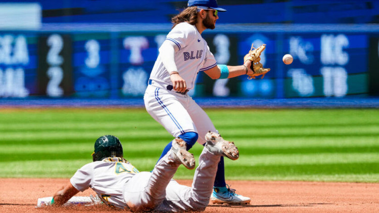 Carlos Perez of the Oakland Athletics slides into second base as Bo Bichette of the Toronto Blue Jays attempts to make the catch. Photo by Getty Images.